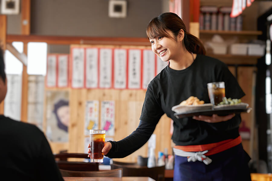 飲み物を提供する女性従業員 写真